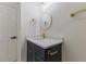 Bathroom with white countertop, dark blue vanity, gold fixtures, and round mirror under modern lighting at 4713 Erwin Rd, Durham, NC 27705