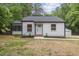 Charming renovated white home featuring a two-car garage, dark trim, and nice landscaping at 4713 Erwin Rd, Durham, NC 27705