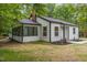 Charming white home with a sunroom, black trim, and a well-maintained lawn at 4713 Erwin Rd, Durham, NC 27705