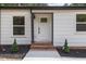 Inviting entryway with a brick landing, dark trim, and decorative plants at 4713 Erwin Rd, Durham, NC 27705