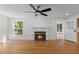 Living room with fireplace, ceiling fan, and a view to the kitchen at 4713 Erwin Rd, Durham, NC 27705