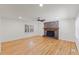 Spacious living room featuring hardwood floors, a ceiling fan, and a classic brick fireplace at 4713 Erwin Rd, Durham, NC 27705