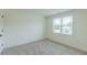 Bright bedroom featuring neutral carpet, white trim, and a window offering natural light at 48 Sanders Farm Dr, Smithfield, NC 27577