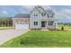 Charming two-story home with stone accents, attached two-car garage, and lush green lawn at 48 Sanders Farm Dr, Smithfield, NC 27577