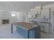 Open-concept kitchen with a gray island, white cabinets, and tile backsplash flows into the living area with a fireplace at 48 Sanders Farm Dr, Smithfield, NC 27577