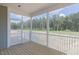 Covered porch features a wood floor, white railings, and a view of the backyard with mature trees at 48 Sanders Farm Dr, Smithfield, NC 27577