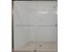 Modern shower with a glass enclosure, white subway tile, and stone-look tile flooring at 48 Sanders Farm Dr, Smithfield, NC 27577