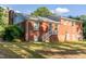 Brick home with staircase to a backdoor, large trees, and big yard at 4813 Glen Forest Dr, Raleigh, NC 27612