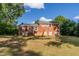 Expansive backyard with brick house and staircase in a serene, tree-lined setting at 4813 Glen Forest Dr, Raleigh, NC 27612