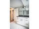 Bathroom vanity with white cabinets, black countertop, drawers, and a view of a modern mirror at 4813 Glen Forest Dr, Raleigh, NC 27612