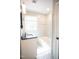 Bright bathroom featuring a vanity with black countertop, bathtub and classic patterned tiled floor at 4813 Glen Forest Dr, Raleigh, NC 27612