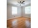 Spacious bedroom with wood flooring, a ceiling fan and two windows providing lots of natural light at 4813 Glen Forest Dr, Raleigh, NC 27612