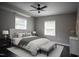 A staged bedroom features a bed, end tables with lamps, bench, area rug, and grey walls at 4813 Glen Forest Dr, Raleigh, NC 27612