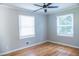 Bedroom featuring wood floors, white trim, and two bright windows at 4813 Glen Forest Dr, Raleigh, NC 27612