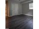 An empty bedroom features a closet, window, grey walls, and hard flooring at 4813 Glen Forest Dr, Raleigh, NC 27612