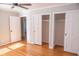 Bedroom featuring wood floors, ceiling fan, open closet, and white trim at 4813 Glen Forest Dr, Raleigh, NC 27612