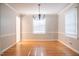 Sunlit dining room featuring hardwood floors, modern chandelier, and neutral paint at 4813 Glen Forest Dr, Raleigh, NC 27612