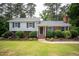 Charming two-story home features a blend of siding and brick, complemented by dark shutters and lush landscaping at 4813 Glen Forest Dr, Raleigh, NC 27612