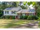 Charming two-story home features a blend of siding and brick, complemented by dark shutters and lush landscaping at 4813 Glen Forest Dr, Raleigh, NC 27612