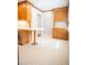 Bright kitchen with wood cabinets, stainless steel dishwasher, and a countertop breakfast bar at 4813 Glen Forest Dr, Raleigh, NC 27612