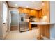 Open kitchen with stainless steel appliances, wood cabinets, and a breakfast bar, seamlessly connects to other spaces at 4813 Glen Forest Dr, Raleigh, NC 27612