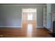Sunlit living room showcasing gleaming hardwood floors and an open doorway to dining room with modern chandelier at 4813 Glen Forest Dr, Raleigh, NC 27612