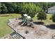 Aerial view of a community playground with slides, swings, benches and a wood chip ground covering at 508 Minerva Dale Dr, Fuquay Varina, NC 27526