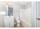 A full bathroom features a vanity, toilet, and shower-tub combo with white tile at 5416 Kissimmee Ln, Raleigh, NC 27616