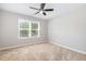 This bedroom features neutral walls, carpet flooring, and a large window with blinds at 5416 Kissimmee Ln, Raleigh, NC 27616