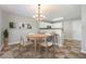 Cozy dining area with wood table, contemporary chandelier, and kitchen bar at 5416 Kissimmee Ln, Raleigh, NC 27616