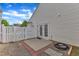 Back patio with a white fence and access to the home through double doors at 5420 Roan Mountain Pl, Raleigh, NC 27613
