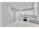 White kitchen with updated appliances, including a refrigerator, microwave, dishwasher, and oven at 5420 Roan Mountain Pl, Raleigh, NC 27613