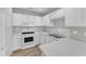 Bright kitchen features white cabinets, countertops, a double sink, and stainless steel appliances at 5420 Roan Mountain Pl, Raleigh, NC 27613