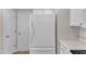 View of the white refrigerator and nearby door in the kitchen at 5420 Roan Mountain Pl, Raleigh, NC 27613