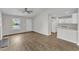 Open-concept living area with fireplace, connecting to a kitchen with white cabinets and appliances at 5420 Roan Mountain Pl, Raleigh, NC 27613