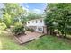Backyard featuring a stone patio, mature trees, and partial fence at 5513 Parkwood Dr, Raleigh, NC 27612