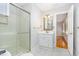 Bright bathroom with a glass shower, white vanity, framed mirror, and marble floors at 5513 Parkwood Dr, Raleigh, NC 27612