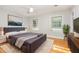 Spacious main bedroom with many windows, hardwood floors, a soft area rug, and modern design at 5513 Parkwood Dr, Raleigh, NC 27612