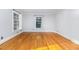 Sunlit bedroom with hardwood floors, large windows, and neutral walls at 5513 Parkwood Dr, Raleigh, NC 27612