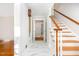 Bright entryway with white marble floors, wooden staircase, and classic accents at 5513 Parkwood Dr, Raleigh, NC 27612