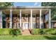 Brick house featuring white columns, black shutters, and a lush green lawn at 5513 Parkwood Dr, Raleigh, NC 27612