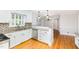 Bright kitchen features custom cabinets, granite countertops, stainless appliances and hardwood flooring at 5513 Parkwood Dr, Raleigh, NC 27612