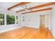 Light filled living room with hardwood floors, beamed ceilings, and large windows at 5513 Parkwood Dr, Raleigh, NC 27612