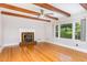 Inviting living room featuring a brick fireplace, hardwood floors, and beamed ceilings at 5513 Parkwood Dr, Raleigh, NC 27612