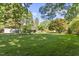 Expansive backyard with a well-maintained lawn, mature trees, and an outbuilding at 5517 Spring Rd, Raleigh, NC 27603