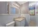 Charming bathroom featuring blue striped wallpaper, vanity with sink, decorative mirror and toilet at 5517 Spring Rd, Raleigh, NC 27603