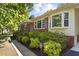 Inviting home exterior featuring brick accents, mature bushes, and well-manicured landscaping at 5517 Spring Rd, Raleigh, NC 27603