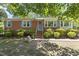 Charming brick home featuring blue shutters and a well-maintained front yard at 5517 Spring Rd, Raleigh, NC 27603