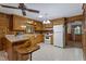 Cozy kitchen with wood cabinetry, white appliances, and a breakfast bar at 5517 Spring Rd, Raleigh, NC 27603