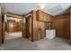 Functional laundry room features wooden cabinets, utility sink, and access to a half bathroom for added convenience at 5517 Spring Rd, Raleigh, NC 27603